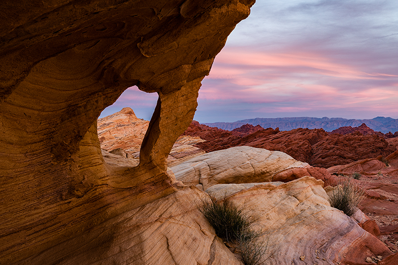 Fire Canyon Arch sunset with glowing tangerine and purple sky